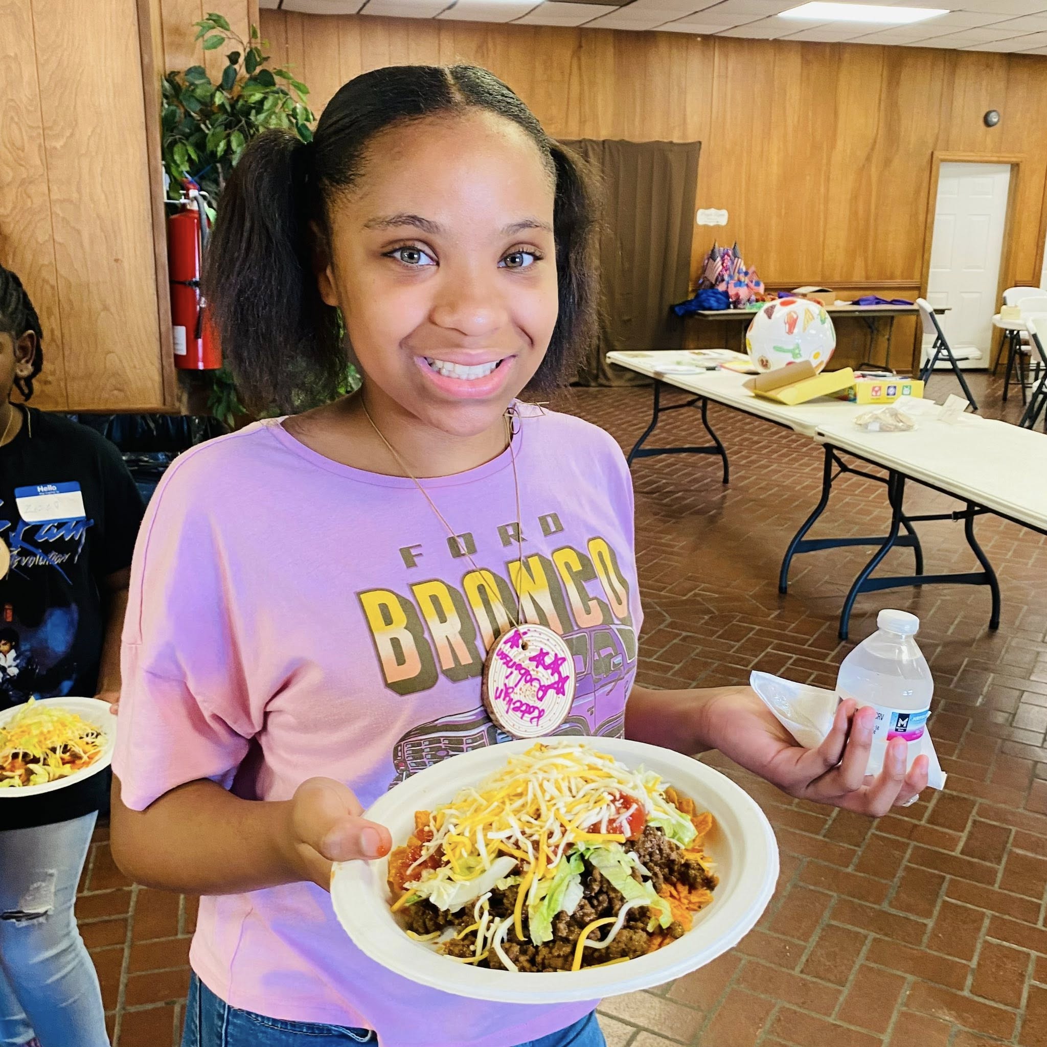 A girl holding a plate of food.